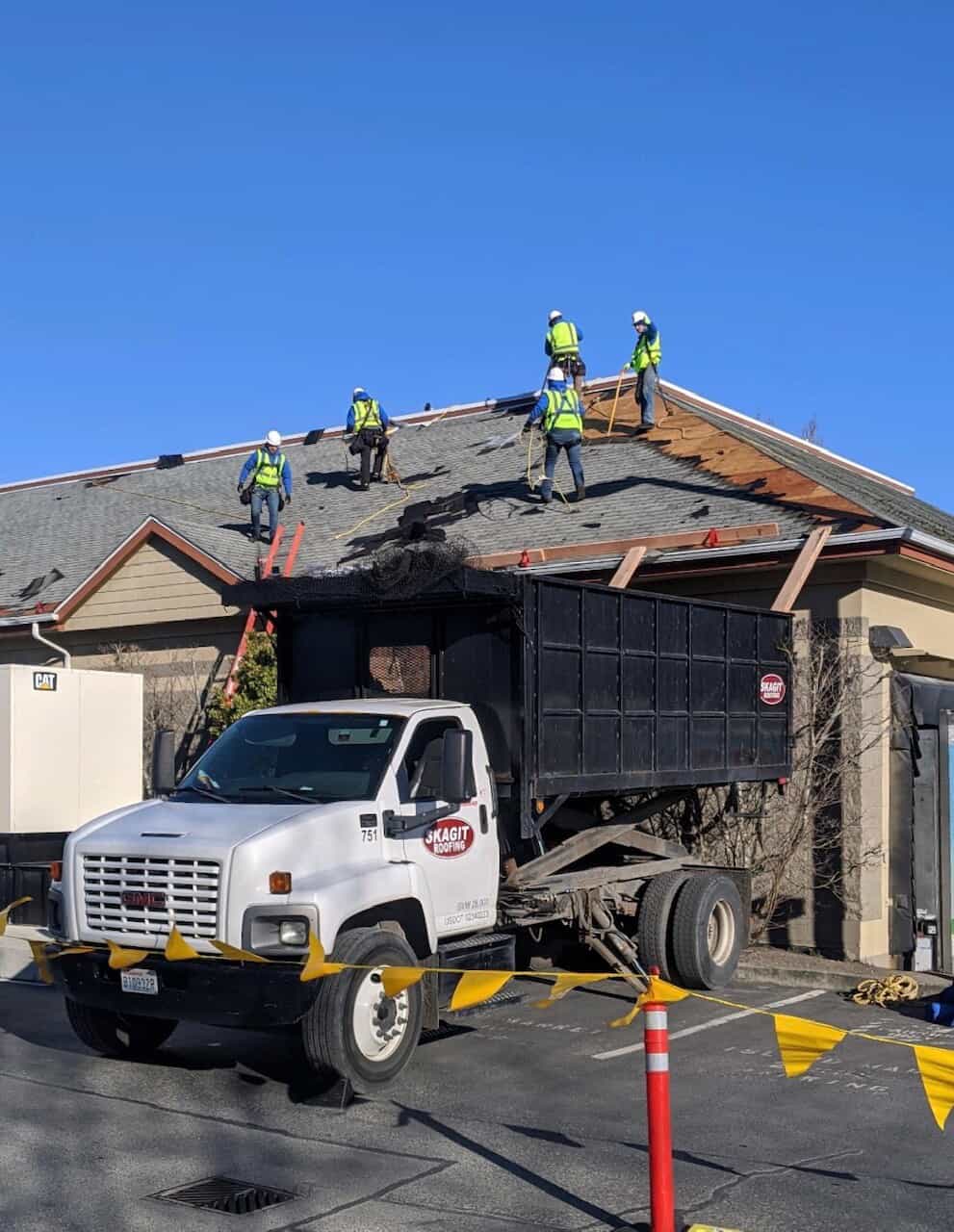 Team of roofers standing on a roof, assembling that roof